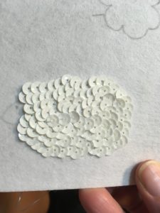 The sequins covered up the sketch and gave the sheep a more natural wool look.